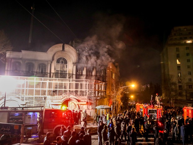Após ser invadido e vandalizado por manifestantes, prédio da embaixada da Arábia Saudita em Teerã, no Irã, é visto com fumaça saindo das janelas (Foto: Atta Kenare / AFP)