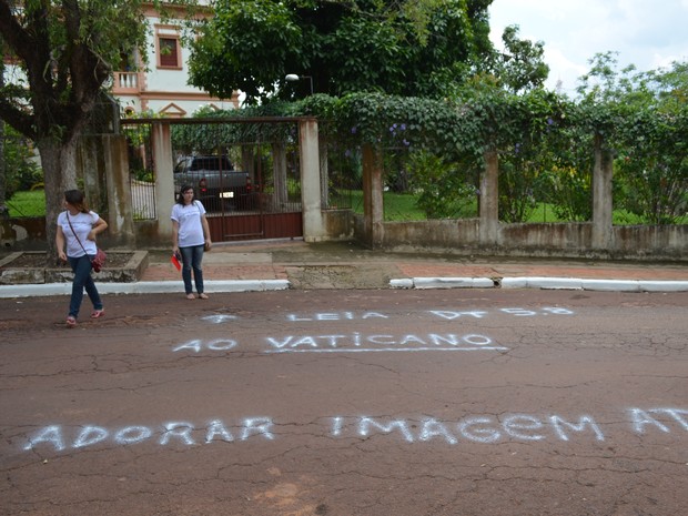 Texto criticando adoração de imagens foi pichado em frente a Casa do Bispo (Foto: Veriana Ribeiro/G1)