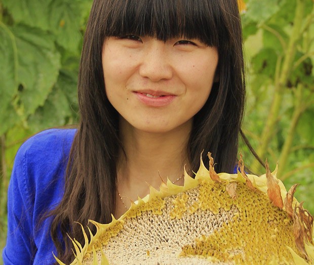 LianJian, da fazenda orgânica HaoBao, em Yunnan, mostra uma flor de girassol gigante com sementes orgânicas prontas para consumo (Foto: Giselle Paulino)