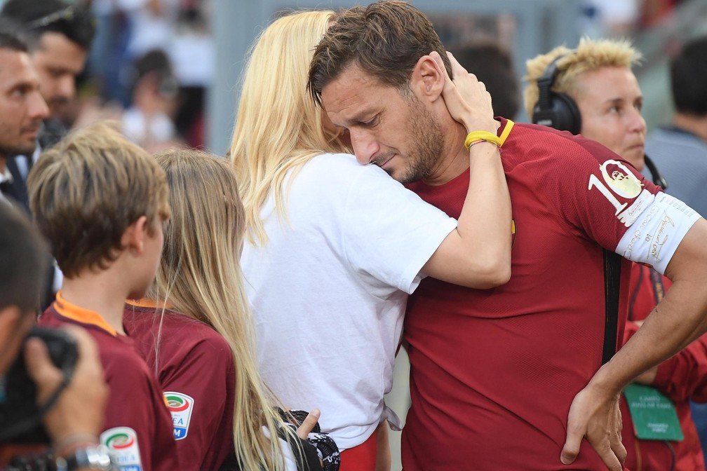O ídolo humano: em lágrimas, o camisa 10 é consolado pela mulher e filhos (Foto: Claudio Peri/EFE)