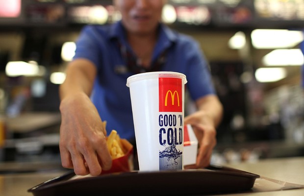 Atendente serve pedido em loja do McDonald's Fast food Junk food (Foto: Getty Images)