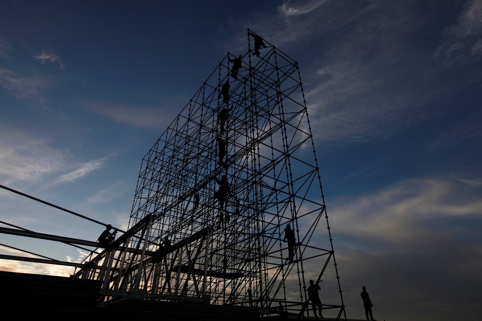 Homens trabalham na construção de uma estrutura de metal em Fortaleza (Foto: Reuters/Paulo Whitaker)