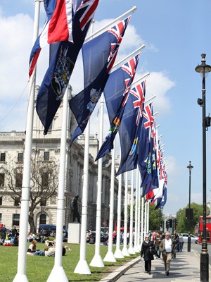 Pessoas passam pelas bandeiras da nação na Praça do Parlamento em Westminster, no centro de Londres (Foto: AFP PHOTO / JUSTIN TALLIS)