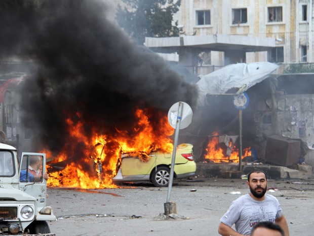 Foto da agência de notícias estatal síria SANA mostra carro em chamas após a explosão de uma das bombas na cidade de Tartus (Foto: Sana via AP)