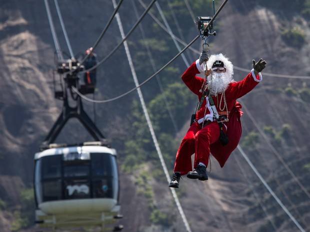 Um homem vestido de Papai Noel desceu de tirolesa pelos cabos do bondinho do Pão de Açúcar, no Rio de Janeiro (Foto: Felipe Dana/AP)
