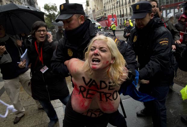 Ativista do Femen é levada por policial após protesto com os seios à mostra (Foto: Pierre-Philippe Marcou/AFP)