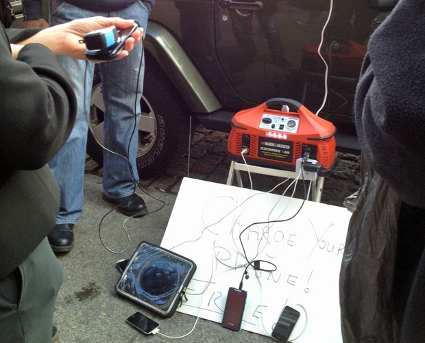 Uma bateria de carro virou fonte para carregar eletrônicos em Nova York (Foto: Serginho Gandolphi/Globo Esporte)