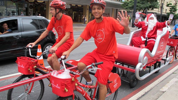 Motorista sorri para o Papai Noel puxado em trenó por quatro ciclistas (Foto: Paulo Guilherme/G1)