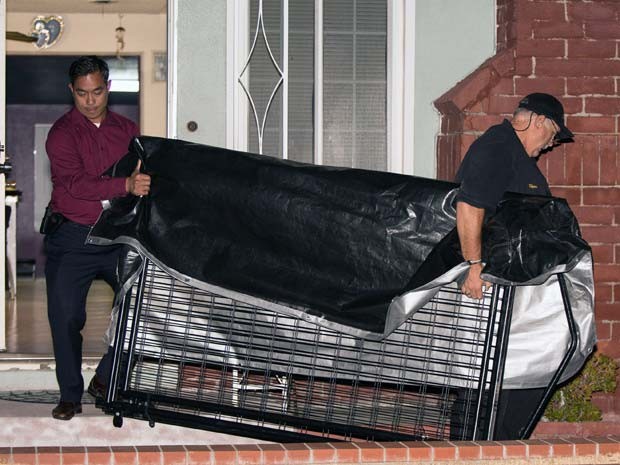 Detetives retiram jaula de residência em Anaheim, na California. A polícia suspeita de que menino de 11 anos ficava preso (Foto: AP Photo/Kevin Warn) Detetives retiram jaula de residência em Anaheim, na California. A polícia suspeita de que menino de 11 anos ficava preso (Foto: AP Photo/Kevin Warn)