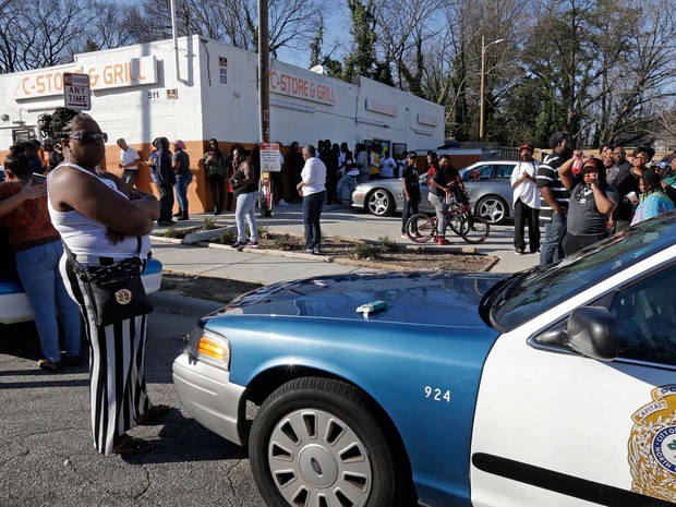 Moradores de Raleigh, nos Estados Unidos, se reúnem perto de cena de morte de homem por policiais nesta segunda-feira (29) (Foto: AP Photo/Gerry Broome)