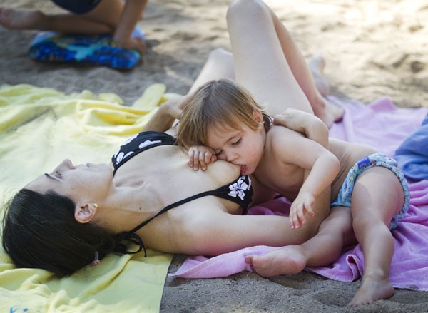 Crianças aproveitaram a praia e a mãe na tarde de verão nesta terça (24). (Foto: Jaime Reina/AFP)