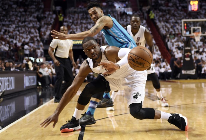 Dwyane Wade tenta segurar a bola para o Miami Heat no confronto com os Hornets (Foto: Reuters)