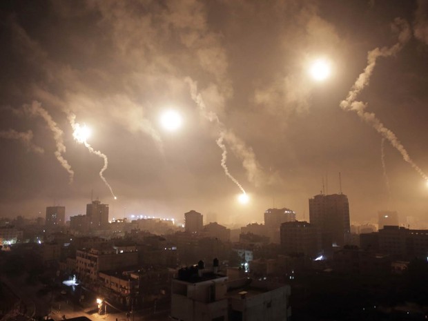 29/7 - Sinalizadores atirados por Israel iluminam o céu da cidade de Gaza na madrugada (Foto: Khalil Hamra/AP)