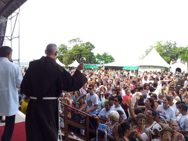 Frei jogando água benta nos fiéis em missa do oitavário, no Convento da Penha (Foto: Juliana Borges/ G1 ES)