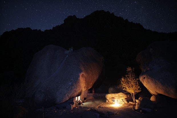 Fogueira ilumina o exterior da casa durante a noite no deserto mexicano (Foto: Daniel Becerril/Reuters)