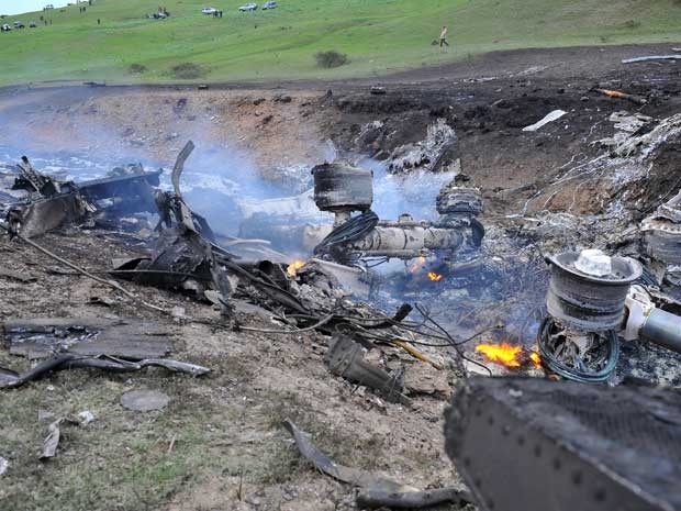 Os restos de um avião dos EUA que explodiu são vistos em uma colina perto das aldeias de Chorgolo e Cholok-Aryk, a 180 km da capital Bishkek do Quirguistão (Foto: AFP PHOTO/ STRINGER )