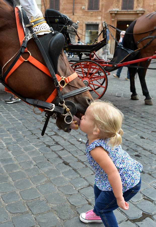 Cavalo reagiu à aproximação da menina, que lhe deu um beijo (Foto: Alberto Pizzoli/AFP)