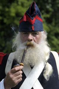 Homem fuma um cachimbo durante a reconstituição da batalha (Foto: Laurent Dubrule/Reuters)