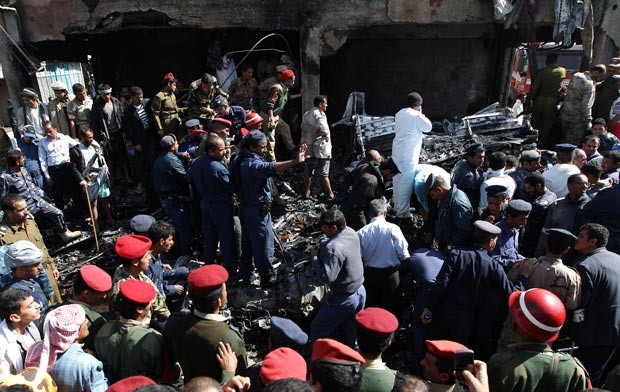 Resgatistas e moradores cercam destroços do avião que caiu nesta quarta-feira (21) no Iêmen (Foto: AFP)