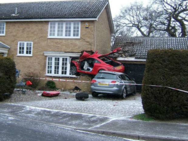 Carro ficou 'entalado' na altura da janela da casa (Foto: Keith Shales/BBC)