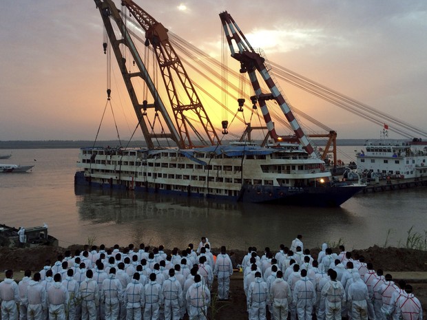 Equipes de resgate ficam na margem do rio enquanto o navio de cruzeiro Estrela do Oriente que naufragou é retirado em Jianli, China. Apenas 14 sobreviventes, um deles o capitão, foram encontrados. O nvio que transportava 456 pessoas (Foto: Reuters) Equipes de resgate ficam na margem do rio enquanto o navio de cruzeiro Estrela do Oriente que naufragou é retirado em Jianli, China. Apenas 14 sobreviventes, um deles o capitão, foram encontrados. O nvio que transportava 456 pessoas (Foto: Reuters)