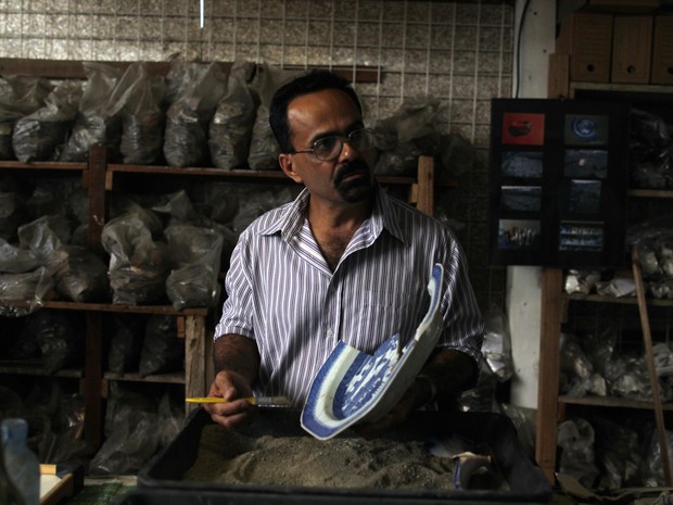 Arqueólogo Claudio Prado de Mello limpa peça de cerâmica encontrada durante obras de expansão do Metrô do Rio (Foto: Pilar Olivares/Reuters)
