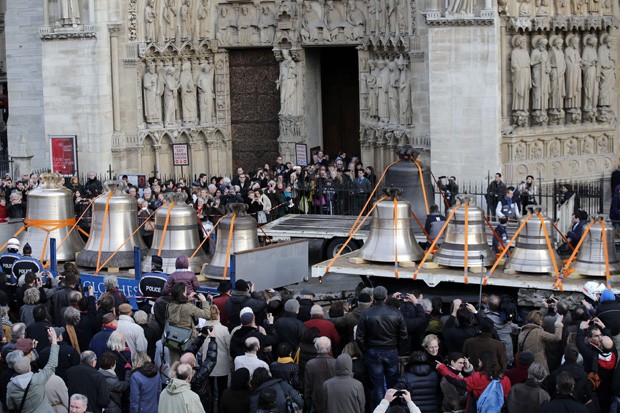 Turistas e curiosos acompanham a chegada dos sinos na Notre Dame (Foto: Christophe Ena/AP)