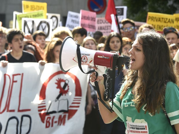 Estudante discursa com megafone durante protesto pelas ruas de Madri (Foto: Gerard Julien/AFP)