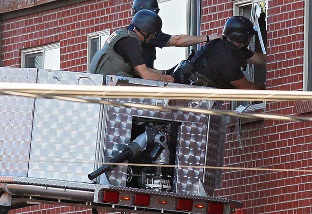 Policiais vasculham o apartamento do suspeito nesta sexta-feira (20) em Aurora, no estado americano do Colorado (Foto: AFP)