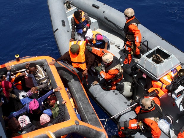 Oficiais alemes ajudam imigrantes resgatados perto da ilha de Lampedusa a embarcar na fragata Hessen, na sexta-feira (8) (Foto: Reuters/Bundeswehr/PAO Mittelmeer/Handout via Reuters)