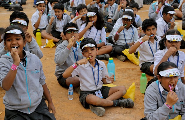 Centenas de crianças escovaram os dentes ao mesmo tempo em uma tentativa de entrar para o Guinness (Foto: Aijaz Rahi/AP)