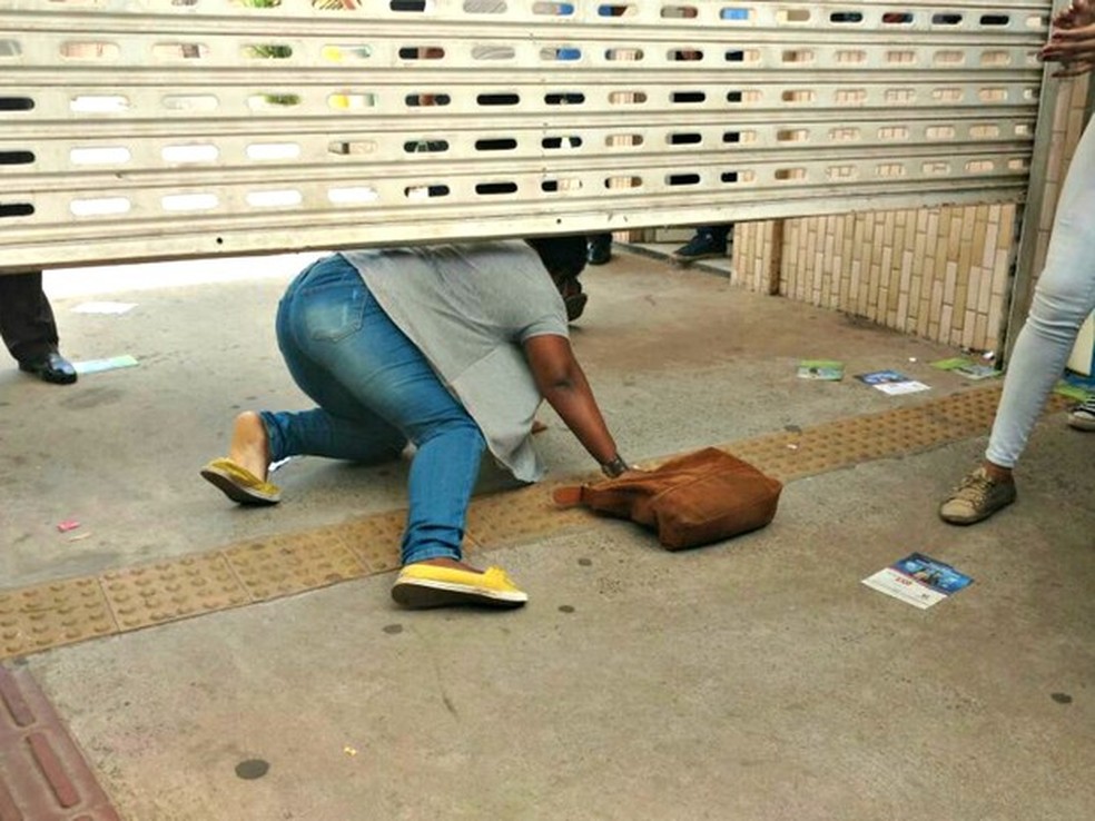 Candidata chegou em cima da hora no primeiro dia do Enem 2016 em Cuiabá, e precisou passar por baixo do portão (Foto: Lislaine dos Anjos/G1)