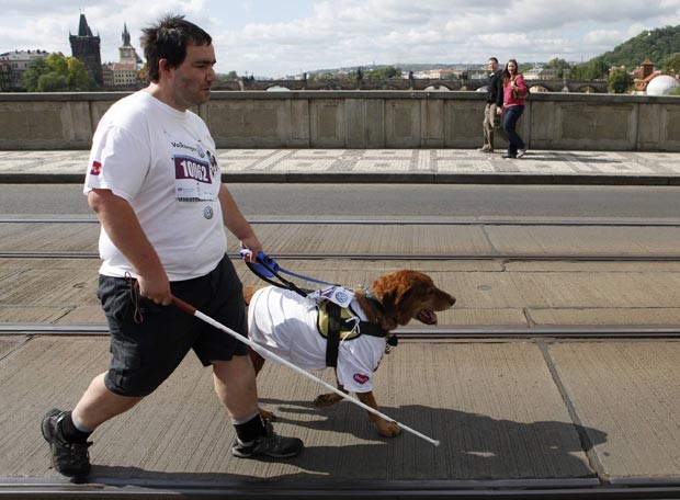 Atleta cego, guiado pelo seu cão, participa da Maratona Internacional de Praga, na República Tcheca, neste domingo (13) (Foto: David W Cerny/Reuters)