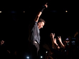 Bruce Springsteen ergue o braço em gesto característico e exibe marca de batom na bochecha durante show em São Paulo (Foto: Caio Kenji/G1)