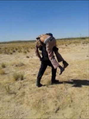 Policial carrega homem achado no deserto no México (Foto: Juárez Municipal Government via El Paso Times/AP)