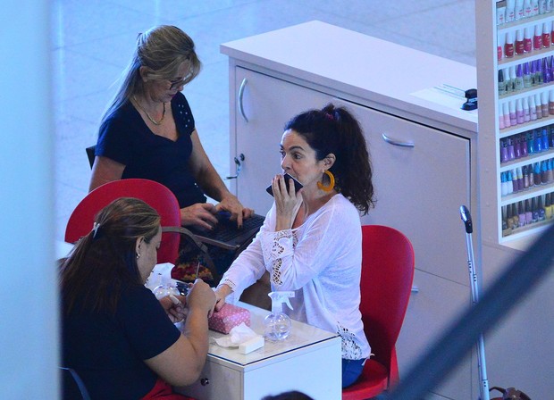 Cláudia Ohana faz as unhas antes de embarcar no aeroporto Santos Dumont (Foto: Willian Oda/Agnews)