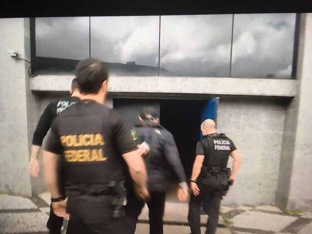 Mantega, de casaco preto e boné, chega à sede da PF em São Paulo (Foto: Reprodução/GloboNews)