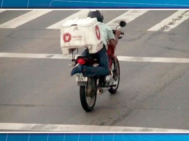 Motociclista tenta esconder placa de moto com os pés na Bahia (Foto: Reprodução/TV Bahia)