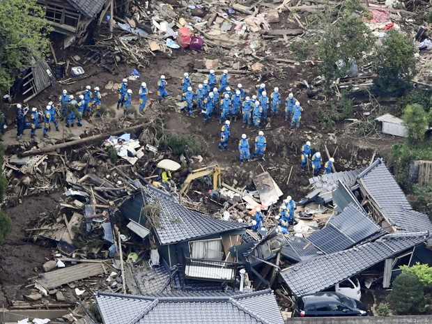Equipes de resgate fazem operação de busca e salvamento em casa que desabou no Japão, após terremoto (Foto: Reuters/Kyodo)