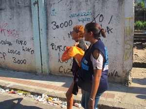 Mulher é levada para abrigo (Foto: Renata Soares/G1)