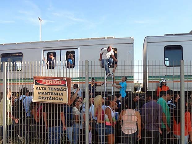 Passageirros deixam trem do Metrô do DF pela janela, depois que uma composição parou por problemas de tração nesta sexta-feira (8) (Foto: Francisco Welson Ximenes Lima/VC no G1)