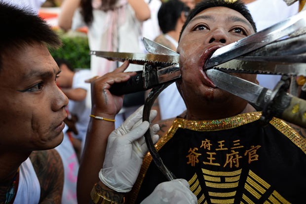 Devotos furam bochechas com metal em ritual de purificação na Tailândia (Foto: Christophe Archambault/AFP)