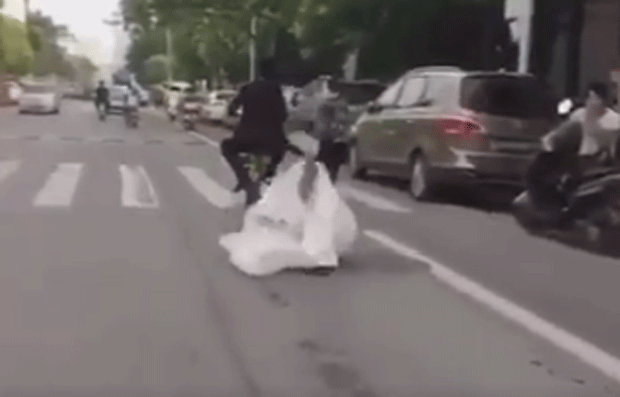 Noivo distraído não percebe queda de noiva de scooter na China (Foto: People's Daily/Facebook)