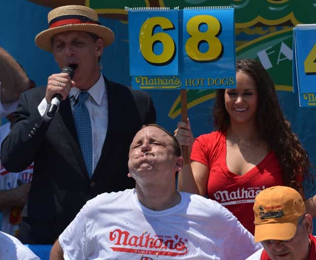 Joey Chestnut come o último dos 68 hot dogs pouco antes de ganhar o concurso nesta quarta (4) (Foto: AFP)