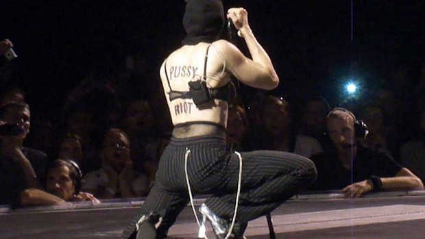 Em foto feita com um celular, a cantora Madonna é vista com o nome da banda Pussy Riot pintado em suas costas durante apresentação em Moscou. O ministro russo Dmitri Rogozin chamou a cantora de 'puta velha' na web por conta da atitude. (Foto: Oleg Sharan/AP)