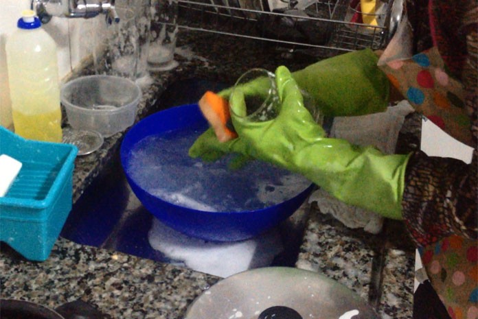 Como economizar água lavando a louça com uma bacia na pia