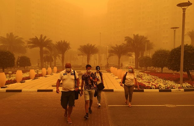 Estrangeiros usam máscaras durante tempestade de areia em rua de Dubai nesta quinta-feira (2) (Foto: Marwan Naamani/AFP)