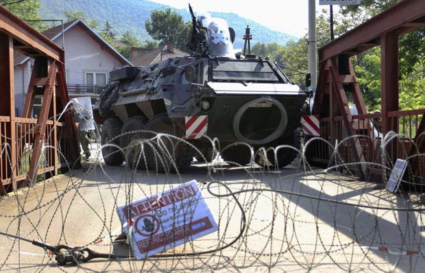 Soldados alemães da Otan patrulham ponte próximo à cidade de Zvecan, em Kosovo, nesta sexta-feira (1º). As tropas de paz entraram em confronto com civis sérvios que tentavam impedir que os militares retirassem os bloqueios. As tropas da Otan bloquearam a  (Foto: AP)