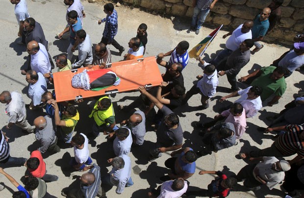 Palestinos participam do funeral da criança de 1 ano e meio que morreu em um incêndio em sua casa em Duma, na Cisjordânia, nesta sexta-feira (31) (Foto: Abed Omar Qusini/Reuters)