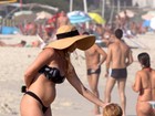 Danielle Winits exibe barriguinha na praia com o namorado e o filho